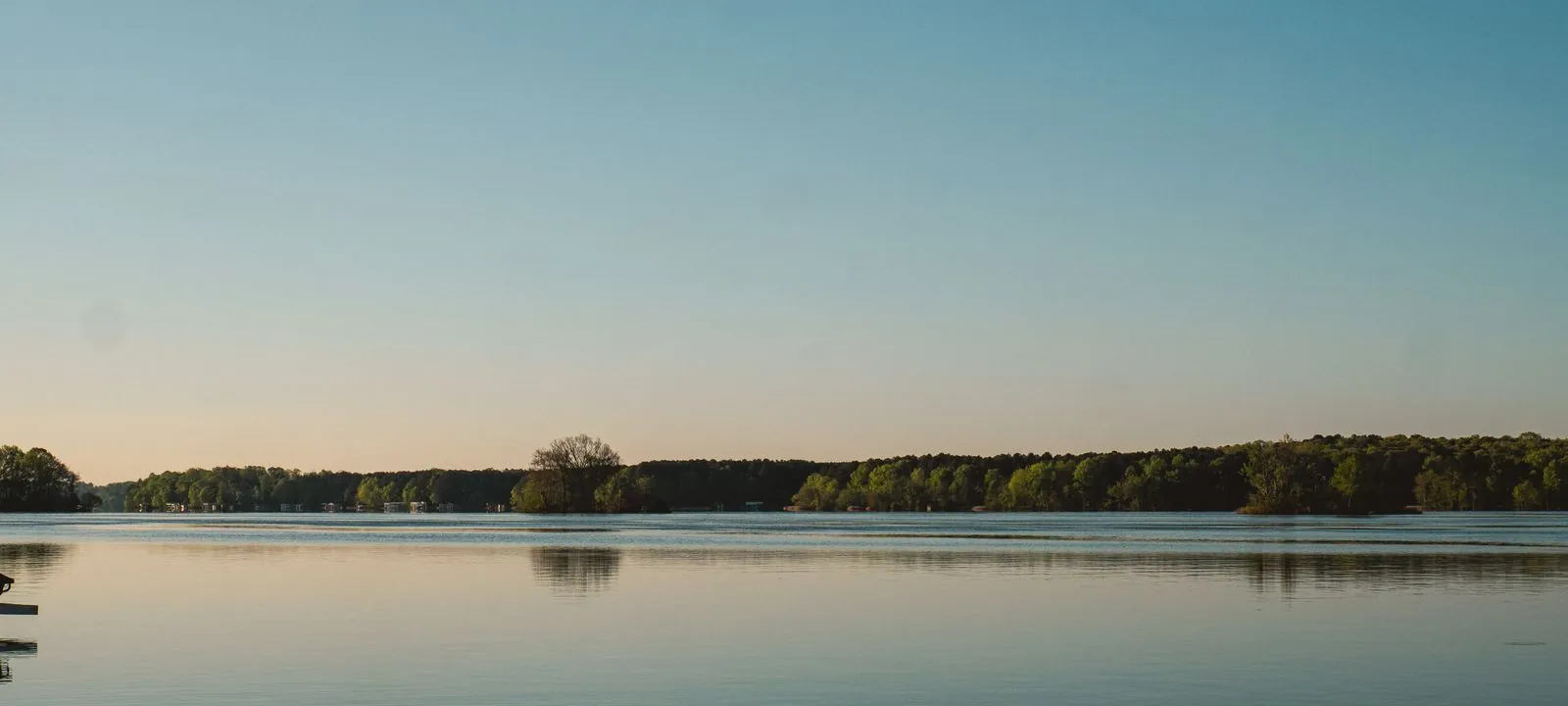 A pale blue lake under an open sky